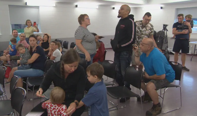 A homophobic preacher (black clothes, standing) and a Yellow Vest member (right, blue) harass children and young families at a Pride storytelling event in Ottawa.